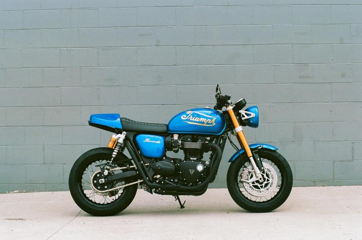 Η Triumph Originals 2025 ξεκίνησε με την παρουσίαση συμμετοχών από οκτώ χώρες και των κριτών που θα επιλέξουν την πιο πρωτότυπη custom Bonneville  Με θέμα το “Icons of British Originality”, κάθε ομάδα της Triumph συνεργάστηκε με έναν τοπικό custom builder για να δημιουργήσει μια μοτοσυκλέτα που αποτυπώνει την πολιτισμική επιρροή της Βρετανίας μέσα από το δικό της πρίσμα. Η βάση όλων των συμμετοχών είναι μοντέλα από τη σύγχρονη σειρά Bonneville. Ακολουθούν οι μοτοσυκλέτες που διαγωνίζονται για την διάκριση:  ΗΠΑ – Βασισμένη σε Bonneville T120, η συμμετοχή των ΗΠΑ είναι εμπνευσμένη από την αγωνιστική κουλτούρα της Indianapolis και την αγωνιστική κληρονομιά της Triumph. Η έντονη μπλε και κίτρινη σχεδίαση με vintage λογότυπα δημιουργήθηκε από τον Bret Johnson της Triumph Indianapolis με τη συμβολή του Victor Tulli. Μεξικό – Η Aftercycles σχεδίασε μια Bonneville Bobber εμπνευσμένη από την αγγλική pop κουλτούρα. Ξεχωρίζει η σέλα με την κίτρινη ραφή, φόρος τιμής στο brand Dr. Martens, και το custom σήμα του γκαζιού «Platform 9¾» ως αναφορά στον Harry Potter. Βραζιλία – Το Gaijin είναι ένα σκοτεινό, μινιμαλιστικό café racer βασισμένο σε Speed Twin 1200, σχεδιασμένο από τη Shibuya στο Σάο Πάολο. Χειροποίητες λεπτομέρειες, όπως ο διακριτικός σχεδιασμός στο ρεζερβουάρ και η minimal ουρά, αποπνέουν αίσθηση ταχύτητας ακόμα και σε στάση. Γαλλία – Η FCR Original τίμησε τον παράλληλο δικύλινδρο κινητήρα της Triumph με το Hail to the Twin, βασισμένο στο Speed Twin 1200 RS. Νέα σχεδίαση πίσω μέρους, ειδική μπροστινή ζάντα και custom βαφή με φύλλα χρυσού και χαλκού αναδεικνύουν τις γραμμές της μοτοσυκλέτας. Καναδάς – Η in-house ομάδα της Motos Illimitées παρουσίασε μια Speed Twin 1200 RS με ειδική εξάτμιση από ανοξείδωτο ατσάλι, χαμηλό τιμόνι και custom βαφή σε γραφίτη και χρυσό με χειροποίητα pinstripes και ένα περασμένο λογότυπο της Triumph. Ιταλία – Ο Giuseppe Carucci της South Garage Motor Co παρουσίασε μια αριστοκρατική Bonneville Bobber, εμπνευσμένη από τις Speed Twins των δεκαετιών ’30-’40. Η μοτοσυκλέτα φέρει ριζικά επανασχ